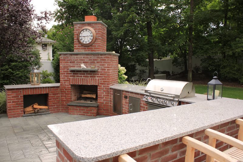 Natural Brick Outdoor Kitchen With Granite Countertop And Fireplace